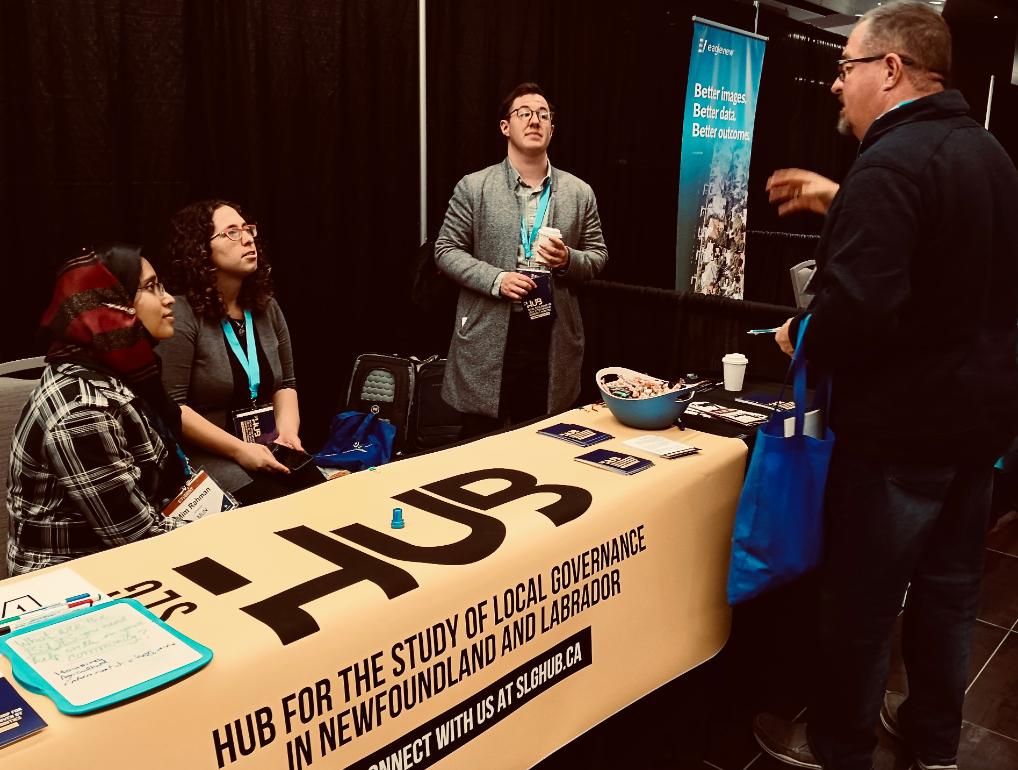 People standing around a conference booth.